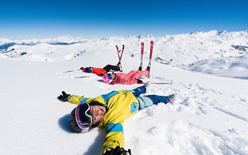 Des enfants allongés dans la neige au ski