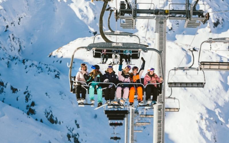 Un groupe de skieuses assises sur un télésiège aux Sybelles