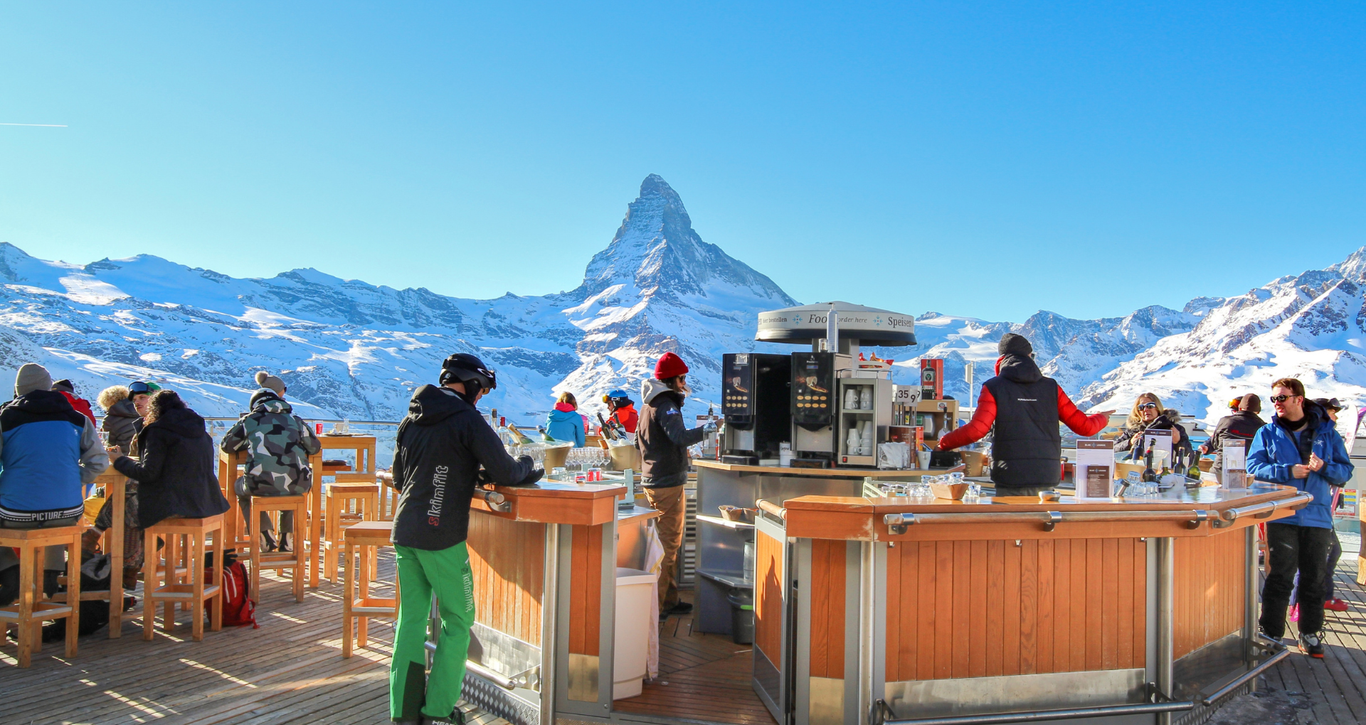 Une terrasse après-ski avec les montagnes enneigées en arrière-plan