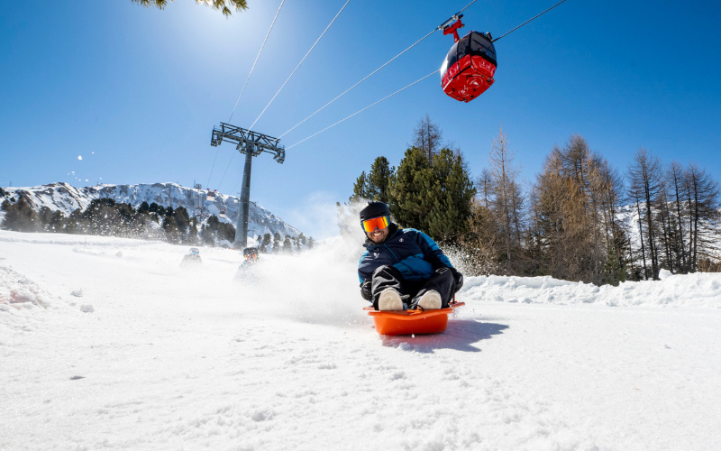 Un homme descendant une piste en luge à La Plagne